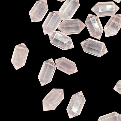 Faceted rose quartz double terminated beads on black background, loose gemstones
