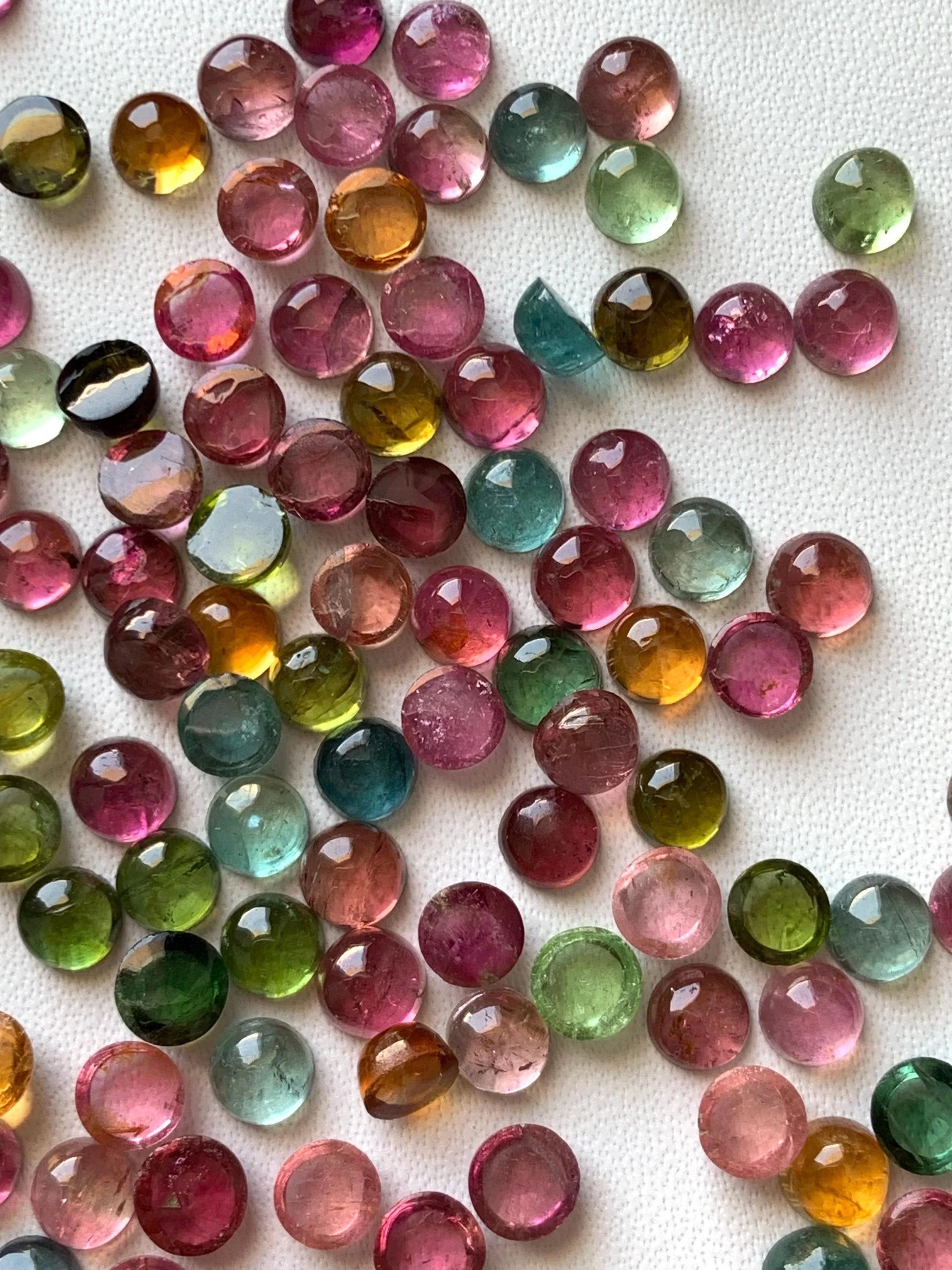 Mixed color round natural tourmaline cabochon gemstones on white background