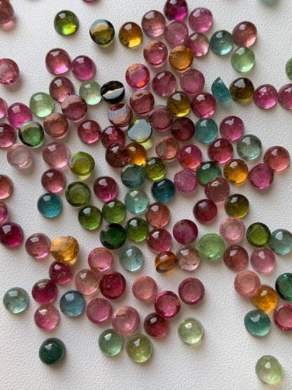 Mixed color round natural tourmaline cabochon beads on white background