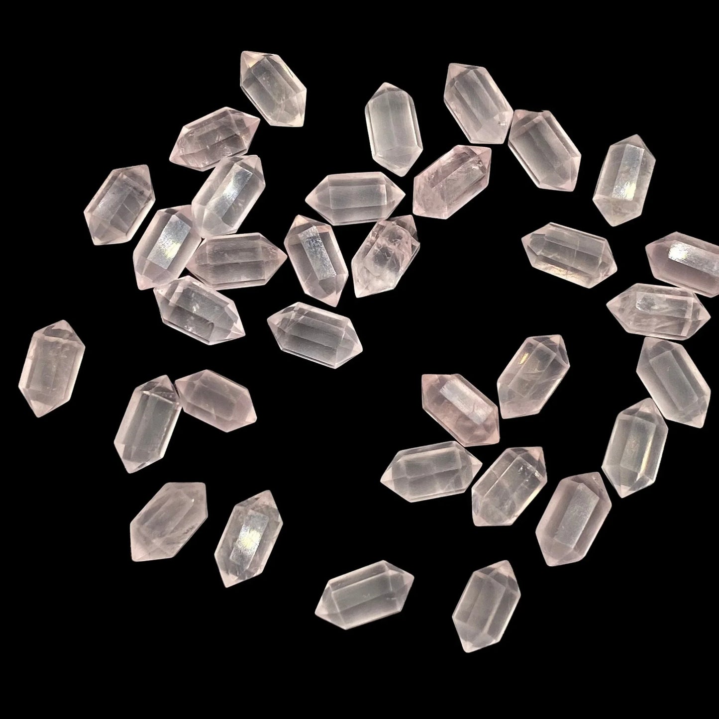 Loose hexagonal rose quartz gemstone beads on black background