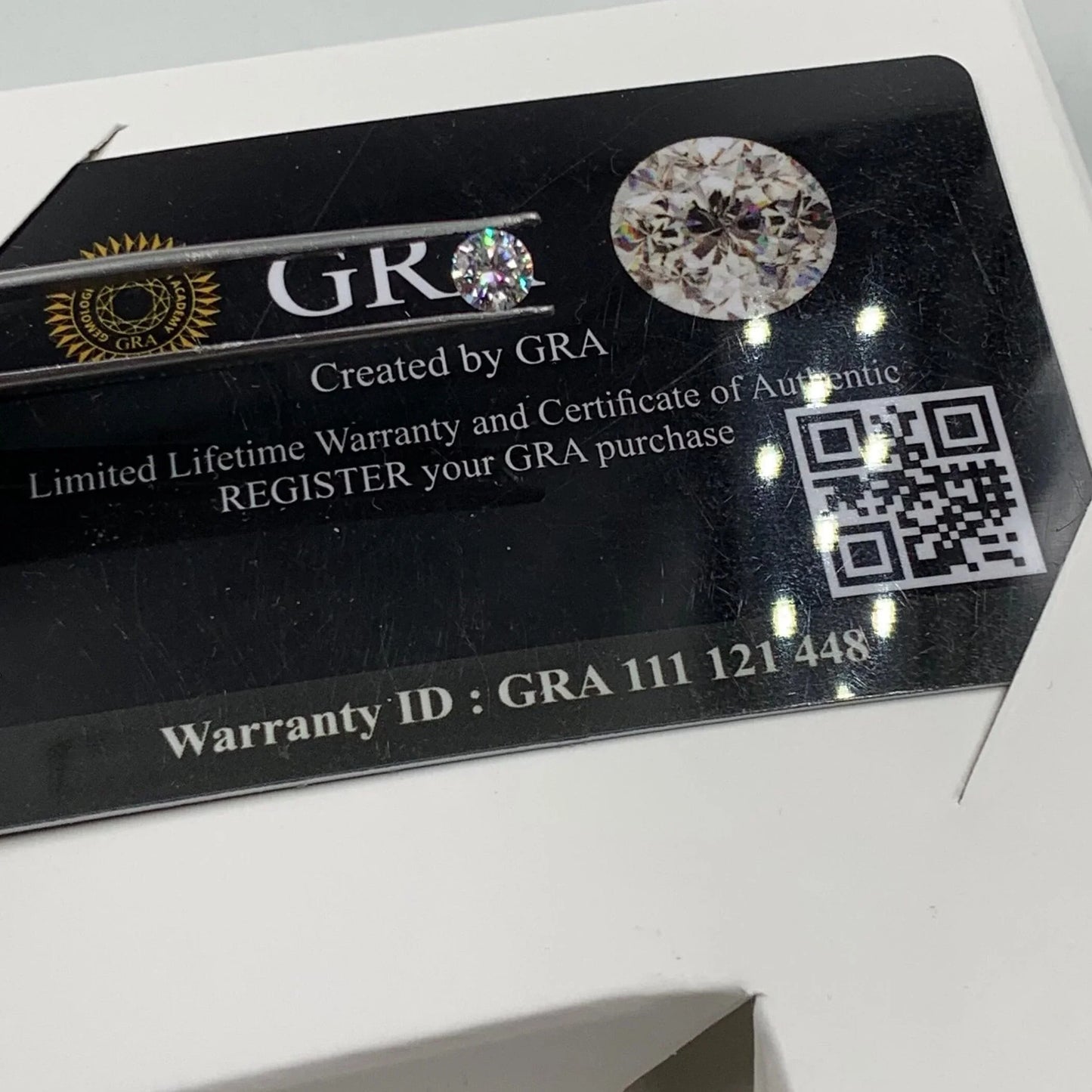 GRA authenticity card with loose gemstone, certificate details, QR code, and warranty ID.