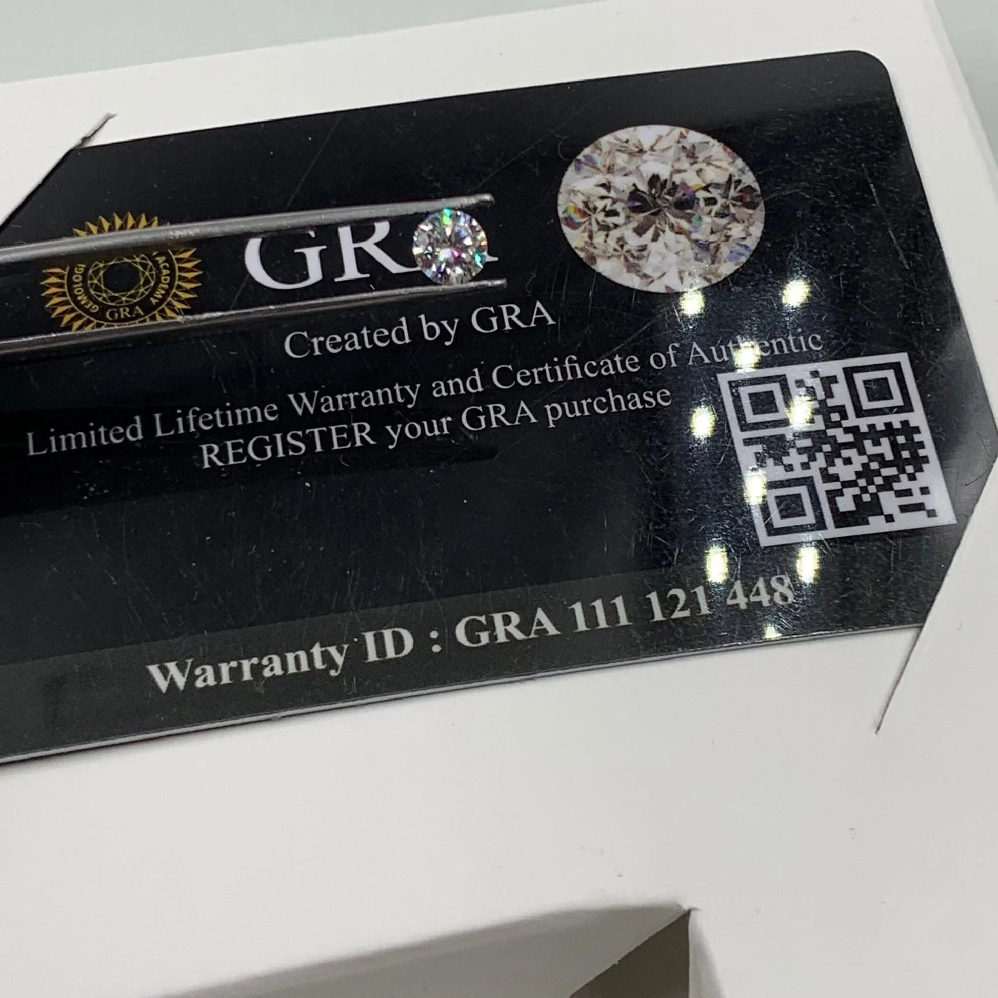 GRA authenticity card with loose gemstone, certificate details, QR code, and warranty ID.