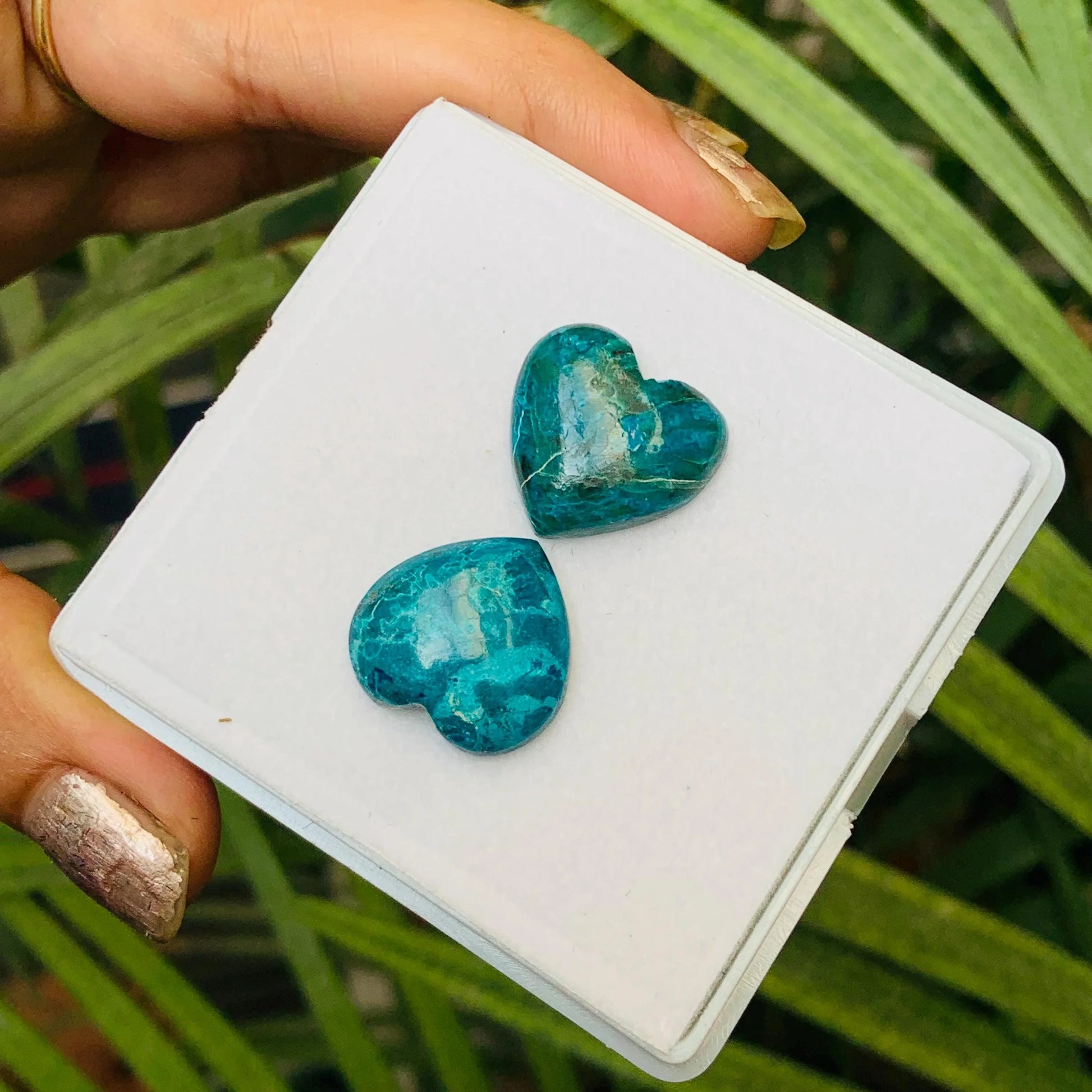 Pair of heart-shaped blue gemstone cabochons for jewelry making on white display card