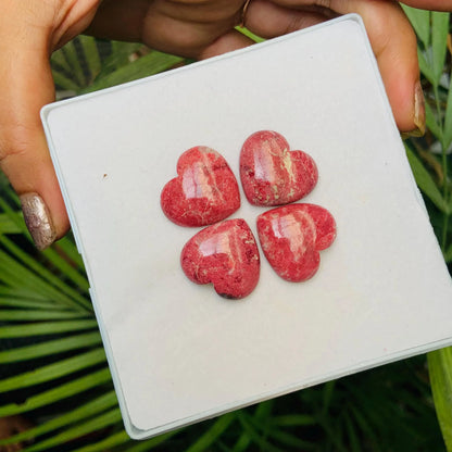 Four polished pink heart-shaped natural gemstone cabochons displayed on a white square card.